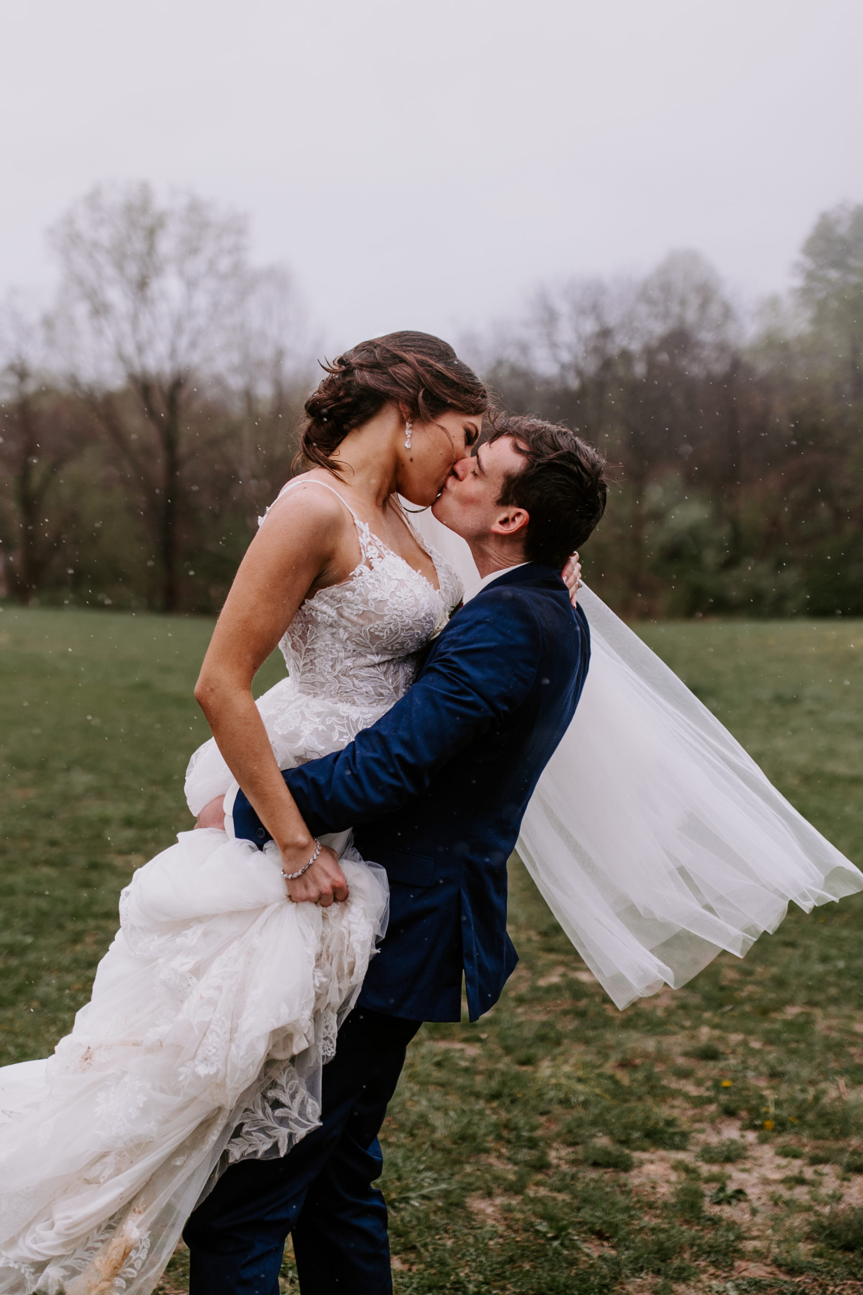 Bride and groom kiss in the rain